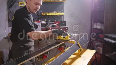 滑雪板保养维修理念.. 车间工人正在打蜡和修理滑雪板和滑雪板